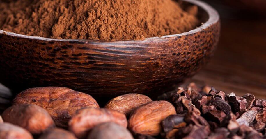 cocoa powder on wooden bowl and cacao seeds