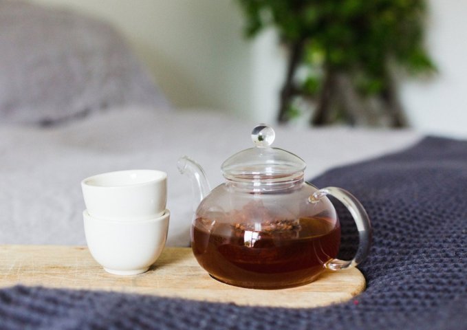 cacao tea in a clear tea pot with two tiny cups