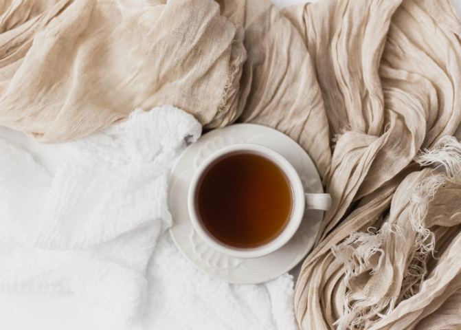 cacao tea on tea cup cozy on sheets top view